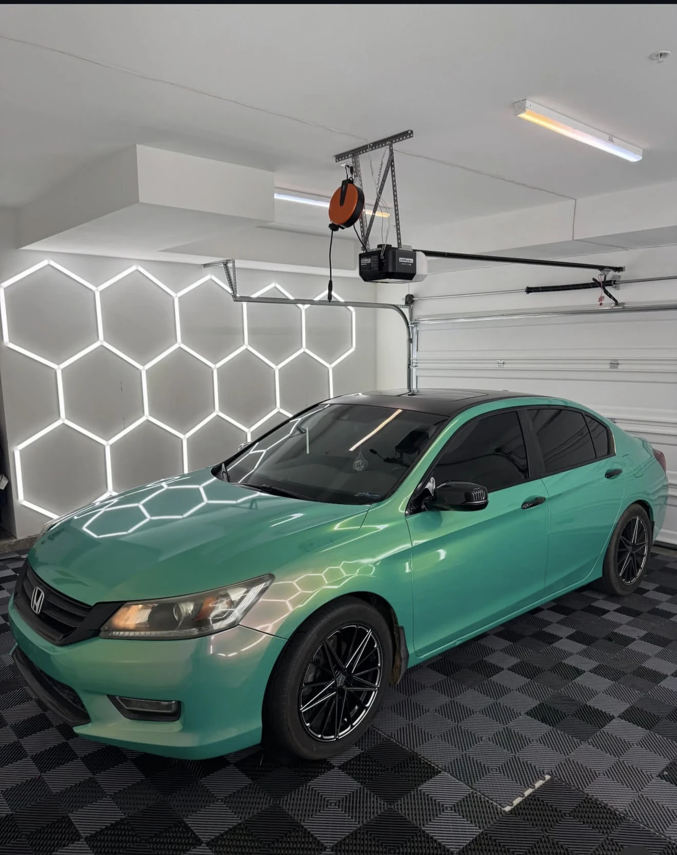 Green Honda with dark windows under studio lights