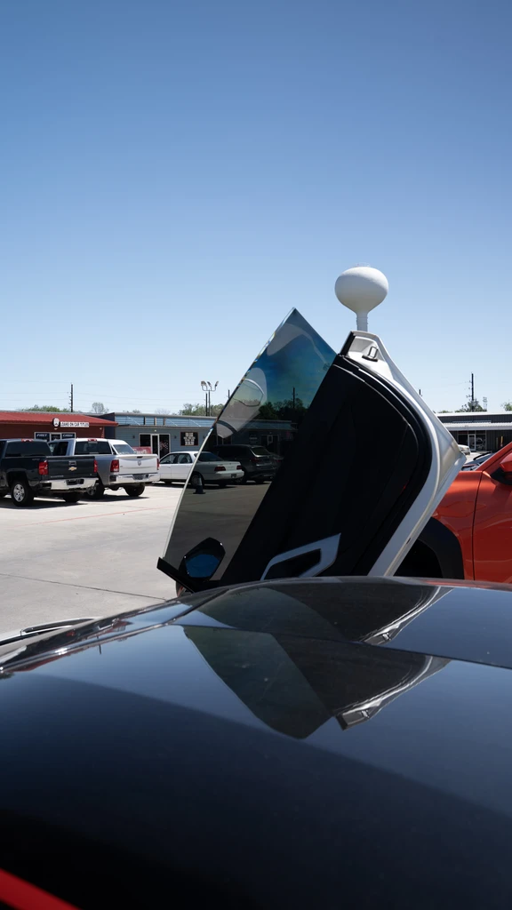 Close view of a dark side window on a raised vehicle door